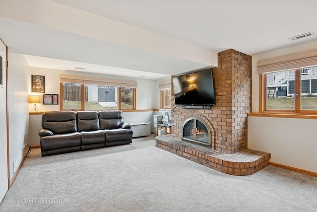 living area featuring carpet, visible vents, and a brick fireplace