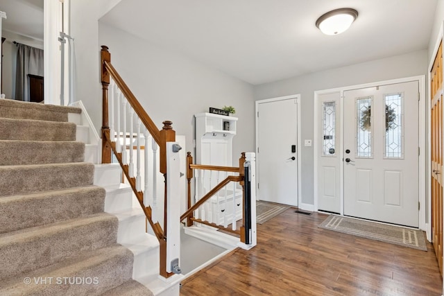 entrance foyer featuring stairs, dark wood-style flooring, and baseboards