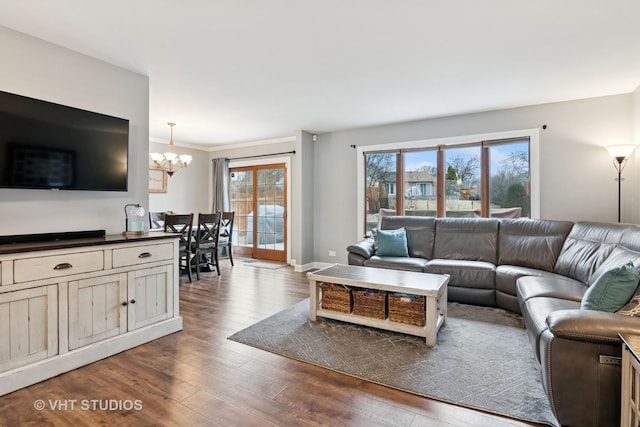 living area featuring a chandelier, wood finished floors, a wealth of natural light, and baseboards