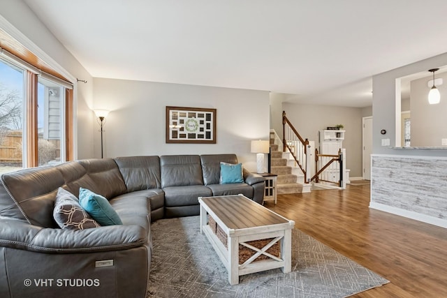 living room with baseboards, stairway, and wood finished floors