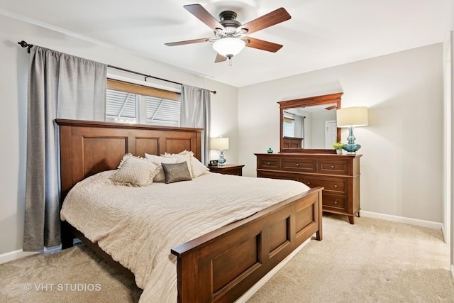 bedroom with a ceiling fan, light carpet, baseboards, and multiple windows