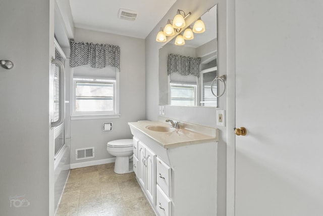 bathroom featuring toilet, vanity, visible vents, and baseboards