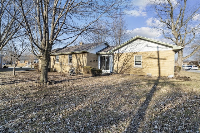 exterior space with a chimney and brick siding