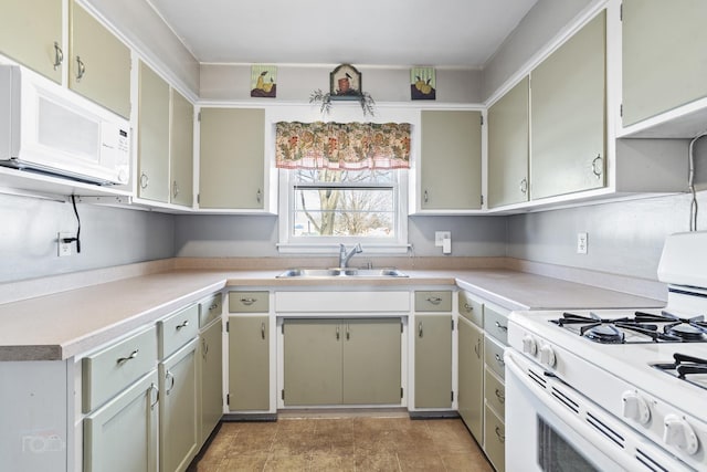 kitchen with white appliances, light countertops, and a sink