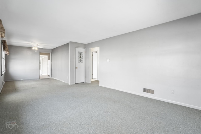 spare room with carpet, visible vents, ceiling fan, and baseboards