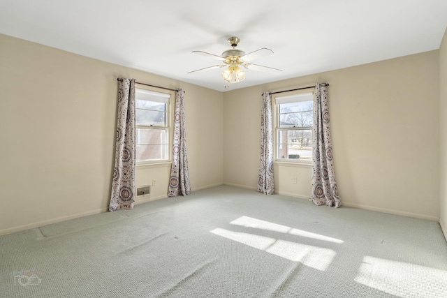 empty room featuring ceiling fan, baseboards, and light colored carpet