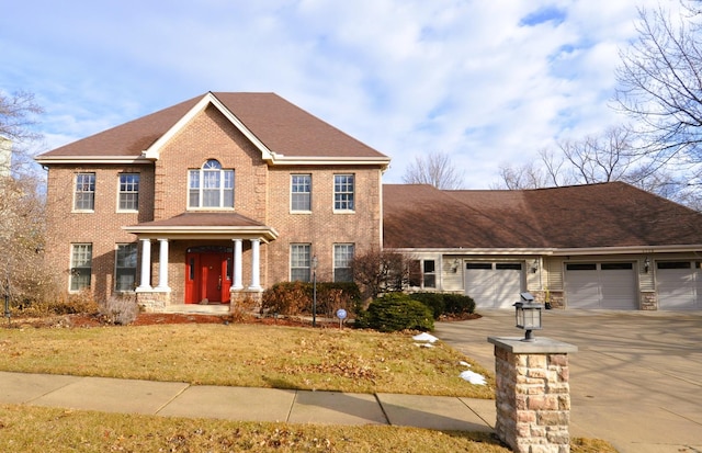 view of front of home with brick siding, a shingled roof, concrete driveway, an attached garage, and a front yard