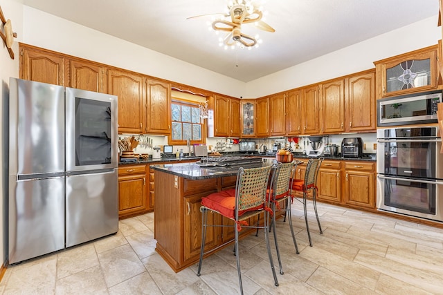 kitchen featuring a kitchen breakfast bar, stainless steel appliances, glass insert cabinets, and brown cabinets