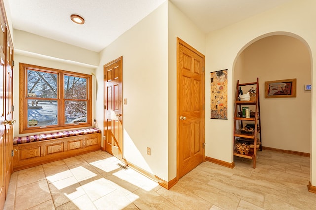 entrance foyer with arched walkways and baseboards