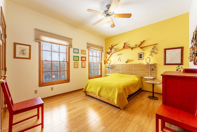 bedroom with ceiling fan, wood finished floors, and baseboards