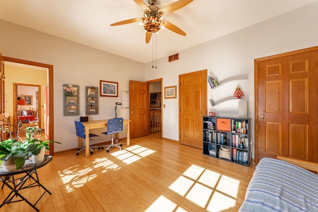 interior space featuring a ceiling fan, light wood-type flooring, visible vents, and baseboards