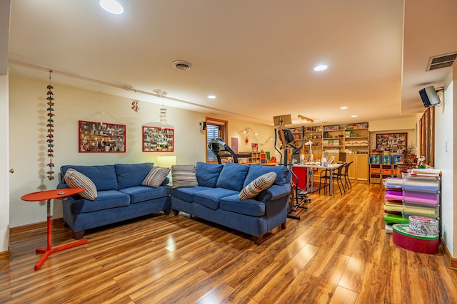 living room with wood finished floors, visible vents, and recessed lighting