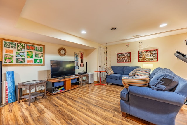 living room with visible vents, wood finished floors, and recessed lighting