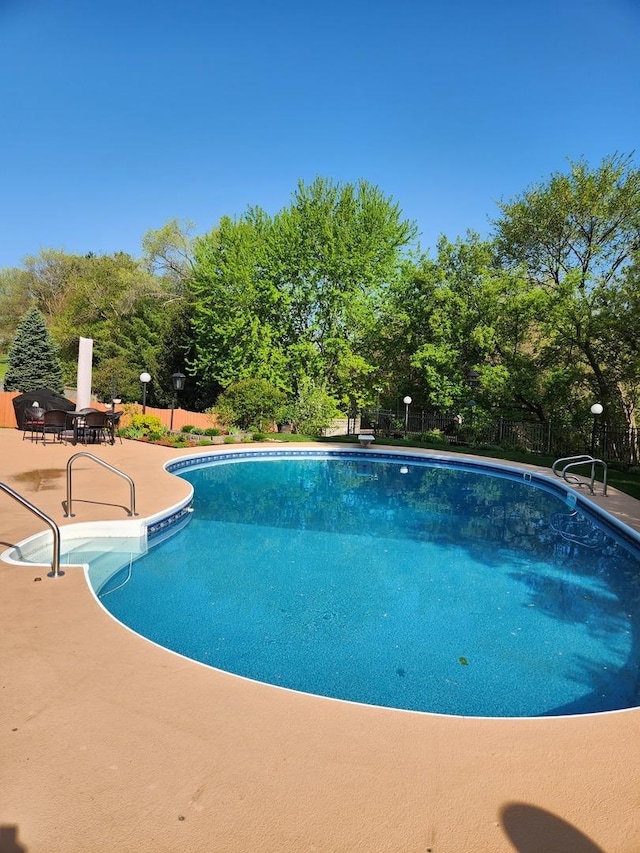 view of swimming pool featuring a fenced in pool, a patio, and fence