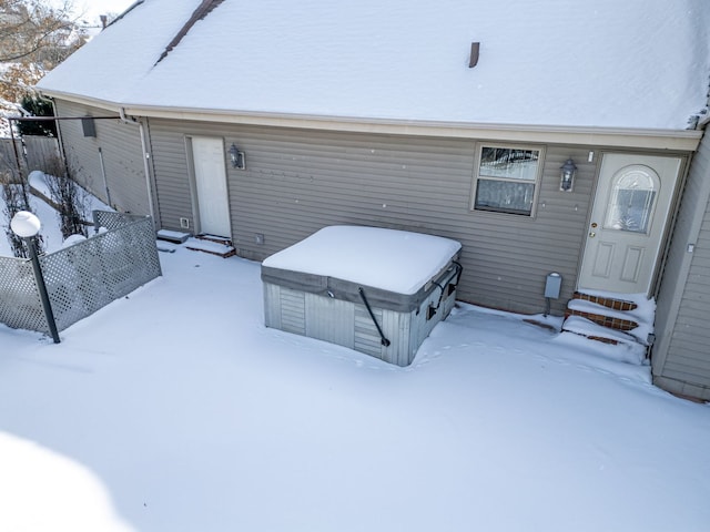 exterior space with entry steps, a hot tub, and fence