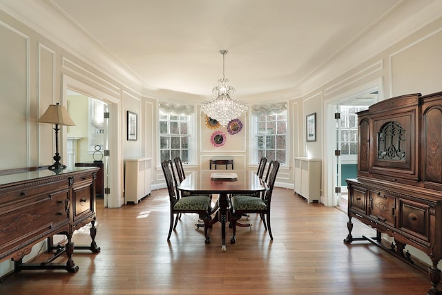 2252 Orrington Ave, Evanston, IL 60201 - dining room with a notable chandelier, ornamental molding, wood finished floors, radiator, and a decorative wall