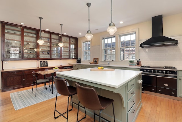2252 Orrington Ave, Evanston, IL 60201 - kitchen with light wood-style flooring, island exhaust hood, backsplash, a center island, and light countertops