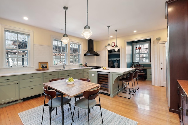 2252 Orrington Ave, Evanston, IL 60201 - kitchen with beverage cooler, tasteful backsplash, light wood-style floors, green cabinets, and wall chimney range hood
