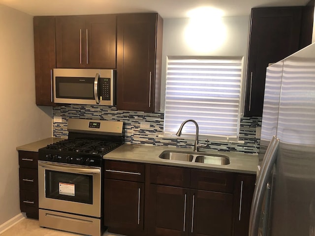 kitchen with stainless steel appliances, a sink, light countertops, dark brown cabinets, and tasteful backsplash