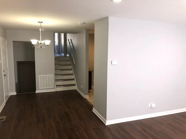 interior space featuring a chandelier, dark wood-style flooring, visible vents, baseboards, and stairs