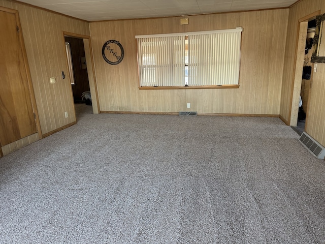 empty room featuring light carpet, visible vents, and crown molding