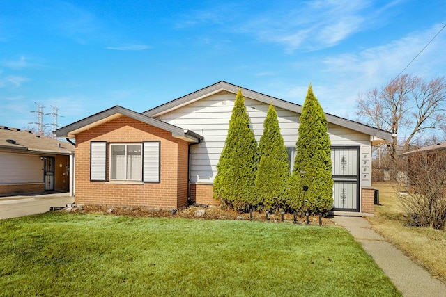 view of front of home with a front lawn and brick siding