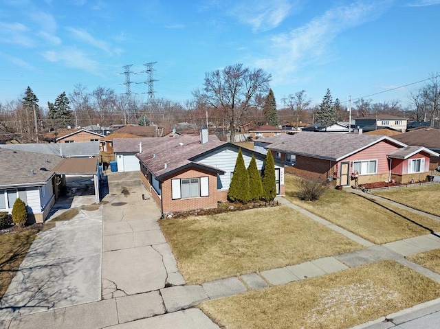 view of front of house with a front lawn, a garage, brick siding, and a residential view