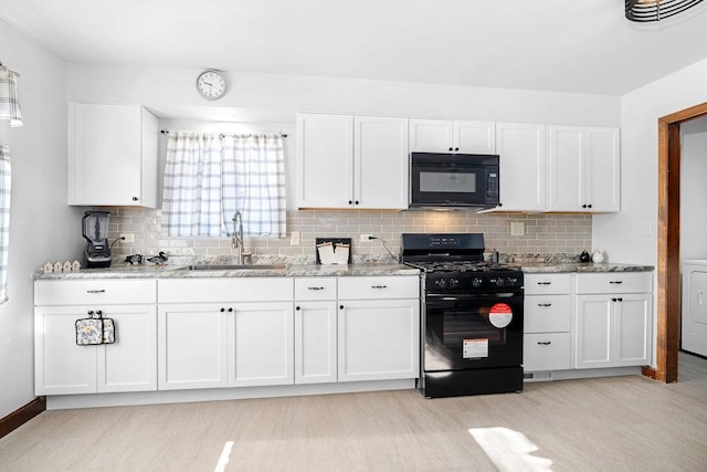 kitchen featuring visible vents, black appliances, a sink, light stone counters, and white cabinetry