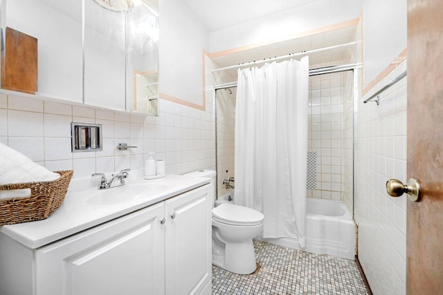 full bath featuring toilet, vanity, tile patterned floors, shower / bath combination with curtain, and tile walls