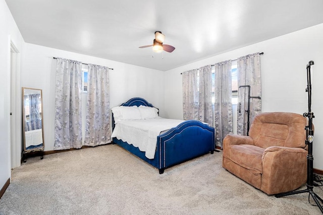 bedroom with a ceiling fan, multiple windows, and carpet