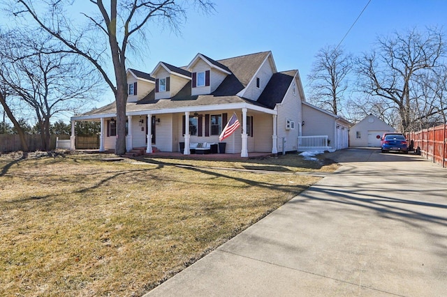 view of front of property with driveway, fence, an outdoor structure, a porch, and a front yard