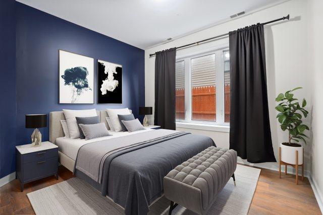 bedroom featuring wood finished floors, visible vents, and baseboards