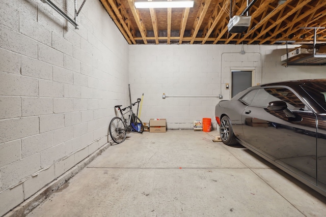 garage with concrete block wall and a garage door opener