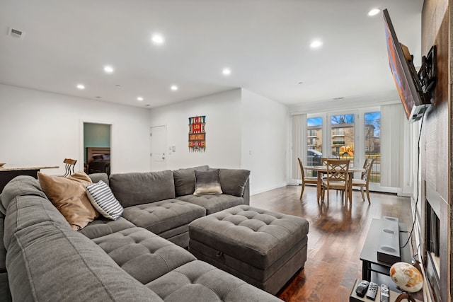 living area with recessed lighting, dark wood-style flooring, visible vents, and baseboards