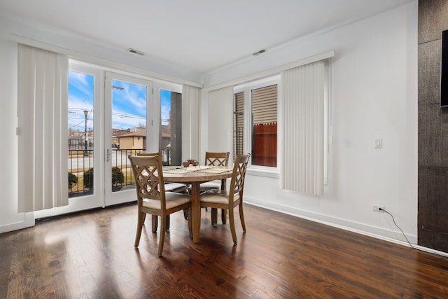 dining space with baseboards, visible vents, and dark wood-style flooring