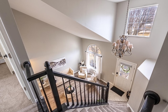 stairs with carpet, baseboards, and a notable chandelier