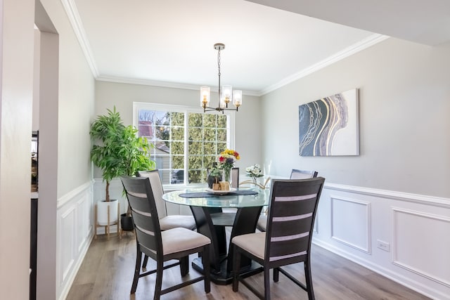 dining area featuring a chandelier, crown molding, and wood finished floors