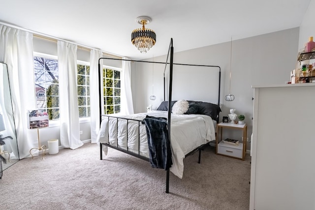 carpeted bedroom featuring an inviting chandelier