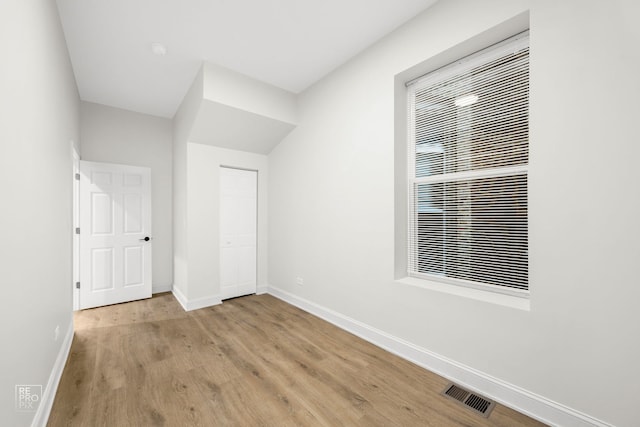 unfurnished bedroom with a closet, visible vents, light wood-style flooring, and baseboards