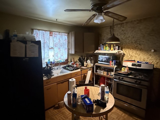 kitchen with a sink, stainless steel appliances, light countertops, and a ceiling fan