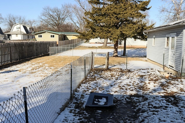 yard layered in snow with a fenced backyard