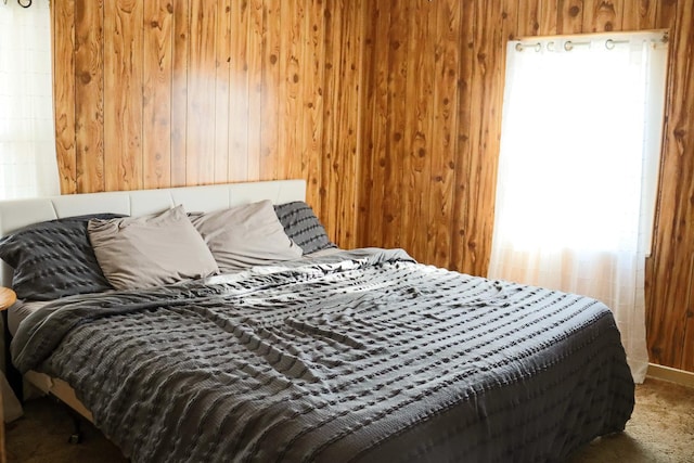 bedroom with carpet flooring and wood walls