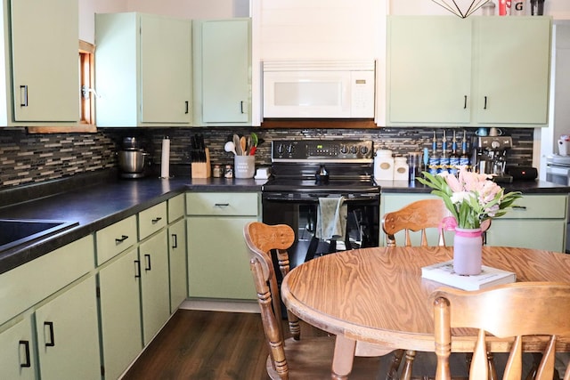 kitchen with dark countertops, black electric range, green cabinets, and white microwave