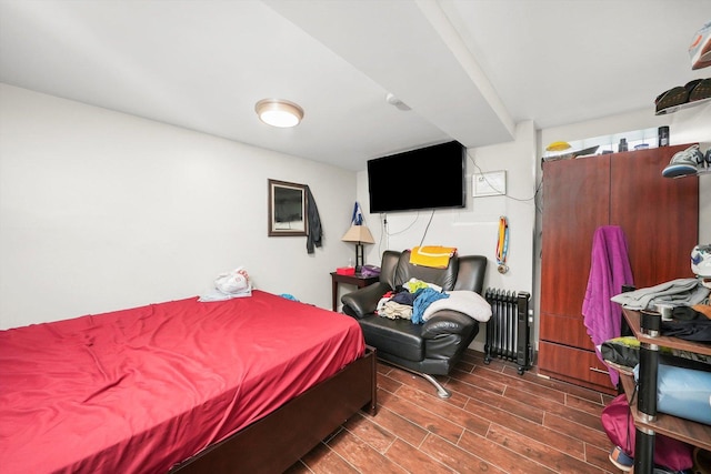 bedroom with wood tiled floor and radiator heating unit