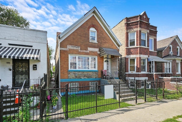 view of front of home with brick siding, a fenced front yard, and a front yard