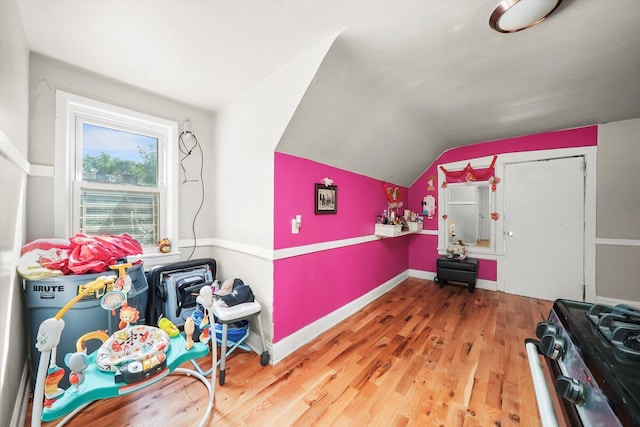 game room with baseboards, vaulted ceiling, and wood finished floors