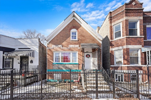 view of front facade with brick siding and a fenced front yard