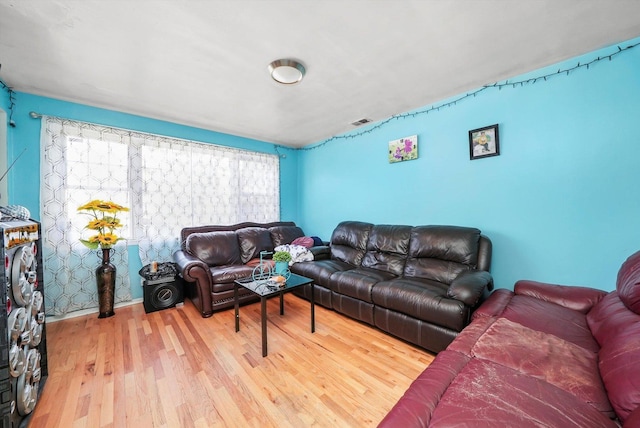living area featuring visible vents and wood finished floors