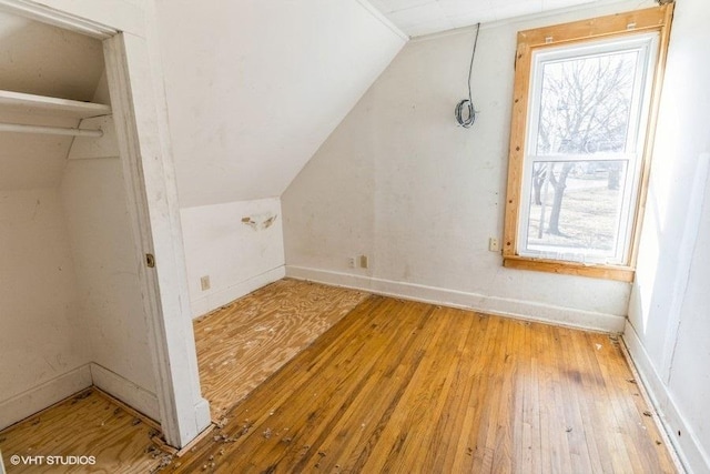 bonus room with baseboards, vaulted ceiling, and hardwood / wood-style floors