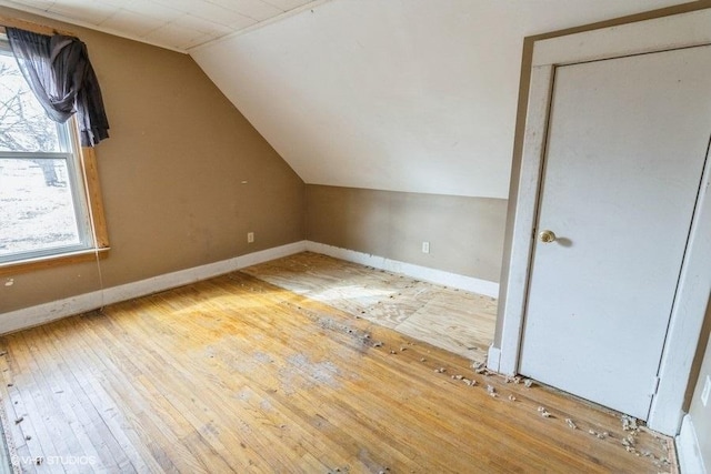 additional living space with lofted ceiling, baseboards, and hardwood / wood-style flooring